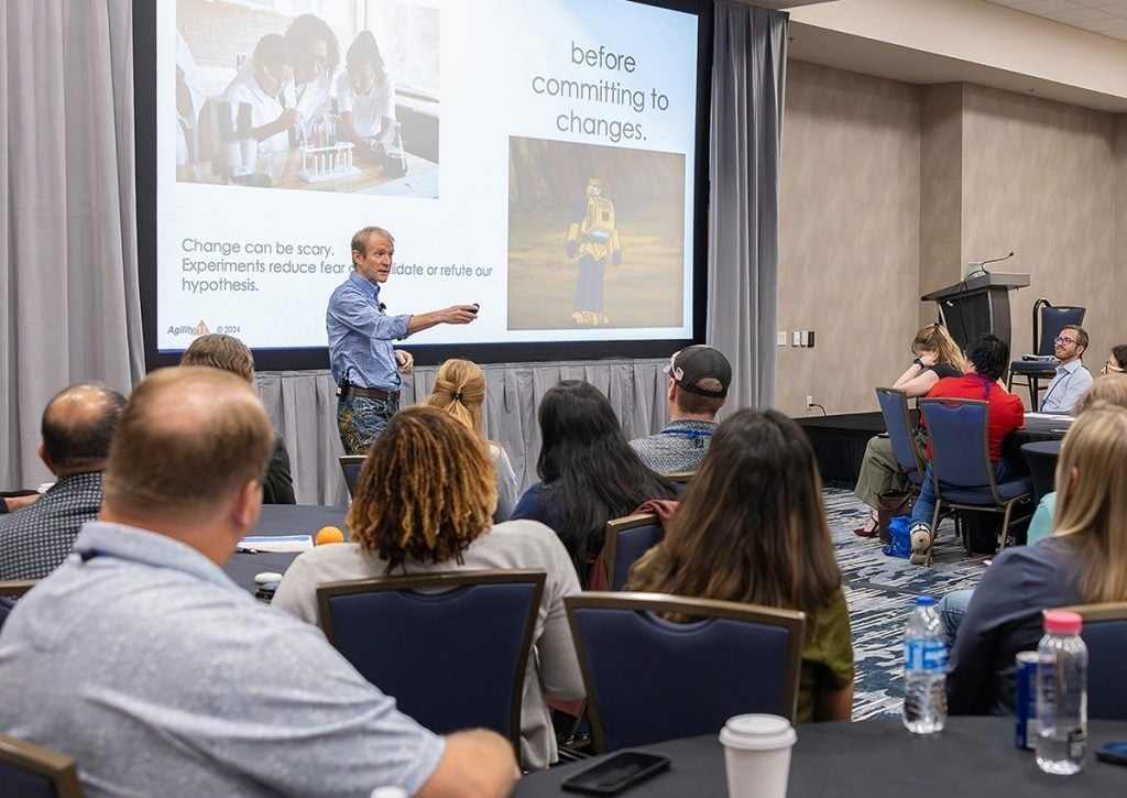 A speaker presenting to attendees during a session at PMI Agile
